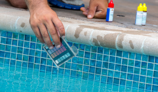 A person testing pool water link to Pools and Spas page